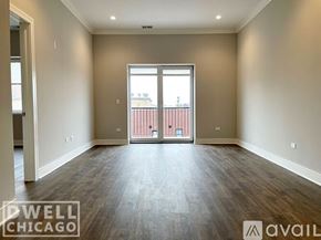 Chicago apartment for rent - A spacious room with a view of a balcony through a sliding glass door.