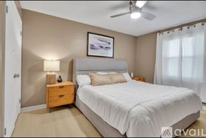 Newburgh apartment for rent - A bedroom with a large bed, a ceiling fan, and a nightstand with a lamp.