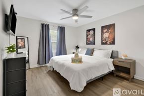 Newburgh apartment for rent - A bedroom with a bed, a dresser, a ceiling fan, and a window with curtains.