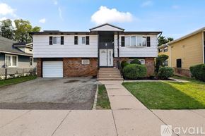 Hempstead apartment for rent - A room with wooden floors and a staircase with a black railing.