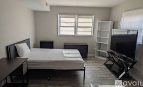 Charlotte house for rent - A bedroom with a bed, desk, and television.