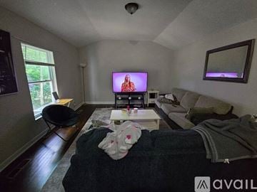 Charlotte house for rent - A living room with a television on, a couch and a chair.
