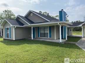 Ponchatoula house for rent - A house with a grey roof and blue trim is for sale.