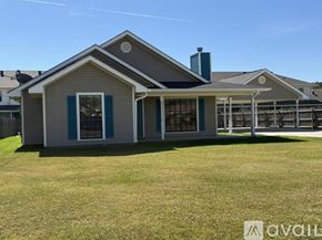Ponchatoula house for rent - A spacious room with wooden flooring and a television mounted on the wall.