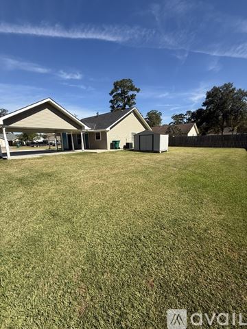 Ponchatoula house for rent - A kitchen with wooden cabinets and a grey fridge.