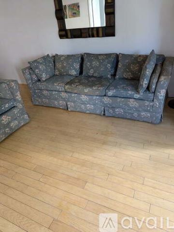 Hallandale Beach apartment for rent - A grey floral patterned sofa with a matching armchair in a room with wooden flooring.