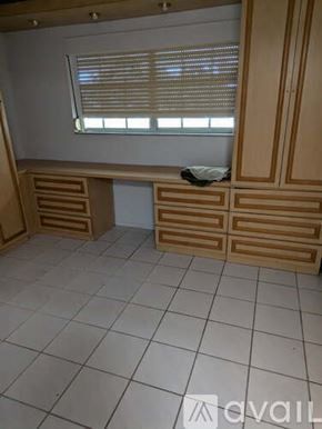 Hallandale Beach apartment for rent - A room with wooden cabinets and a window with blinds.