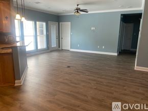 Albany house for rent - A spacious room with wooden flooring and a ceiling fan.