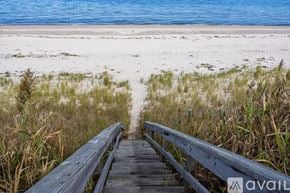 Sandwich house for rent - A wooden walkway leads to a beach.