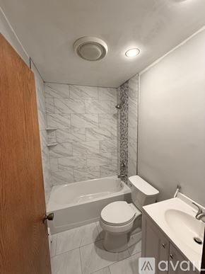 Levittown house for rent - A bathroom with a toilet, sink, and bathtub.
