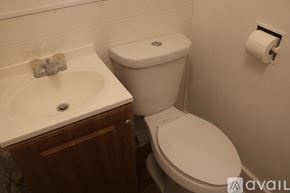 Hutchinson apartment for rent - A white toilet sits next to a white sink in a bathroom.
