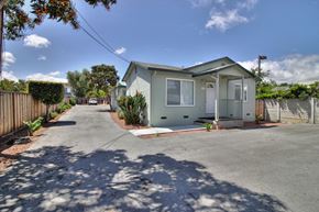 Sunnyvale apartment for rent - A house with a grey roof and white walls is surrounded by a fence and has a driveway in front.
