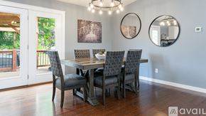 Fairview house for rent - A dining room with a table and chairs and a balcony outside.