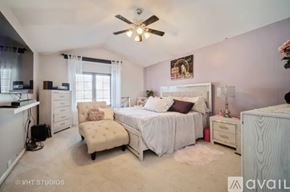Rolling Meadows townhouse for rent - A bedroom with a bed, chair, and a ceiling fan.