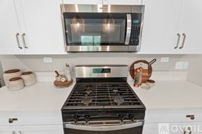 Orange Park house for rent - A modern kitchen with a stainless steel stove and microwave above it.