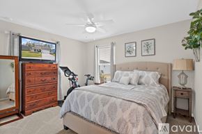 Orange Park house for rent - A bedroom with a large bed and a dresser with a mirror.