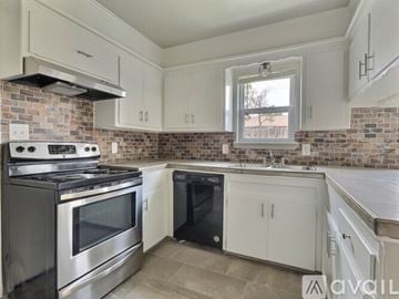 Tulsa apartment for rent - A kitchen with a stove top oven and a black dishwasher.