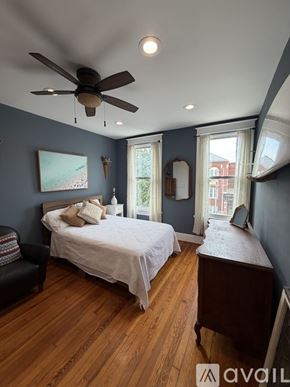 Washington house for rent - A bedroom with a bed, chair, and a ceiling fan.