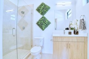 Fort Lauderdale apartment for rent - A bathroom with a toilet, sink, and a glass shower stall.