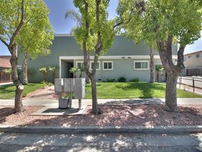Campbell apartment for rent - A house with a green exterior and a tree in front of it.