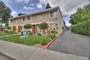Mountain View apartment for rent - A beige building with a green sign in front of it.