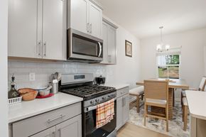 Raleigh house for rent - A kitchen with a stove top oven and a microwave above it.