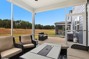 Raleigh house for rent - A patio with a table and chairs overlooking a grassy field.