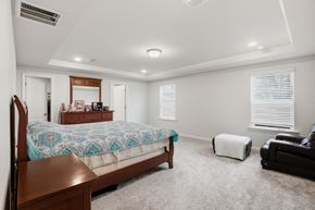 Raleigh house for rent - A bedroom with a bed, chair, and window.