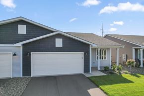 River Falls house for rent - A house with a grey garage door and a brown roof.