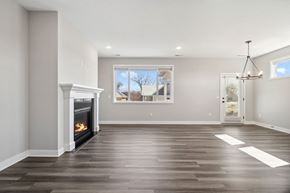 River Falls house for rent - A spacious living room with a fireplace and a chandelier.