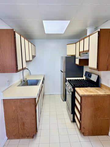Los Angeles apartment for rent - A kitchen with a sink and a stove top oven.