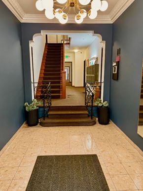 Los Angeles apartment for rent - A hallway with a staircase and a chandelier.