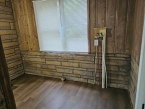 Choctaw house for rent - A room with wooden walls and a window with blinds.