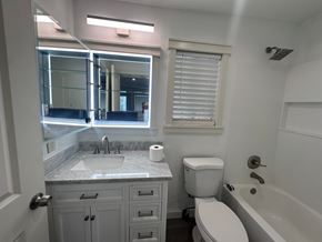 Kailua-Kona apartment for rent - A white toilet sits next to a bathtub in a bathroom.