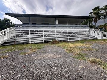 Kailua-Kona apartment for rent - A white building with a black roof and a staircase leading up to it.