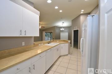 Lehigh Acres apartment for rent - A kitchen with white cabinets and a beige countertop.