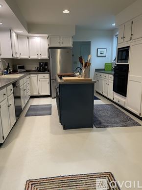 Freeport house for rent - A kitchen with white cabinets and a black island.