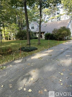 Freeport house for rent - A house is surrounded by trees and a driveway leads to the front door.