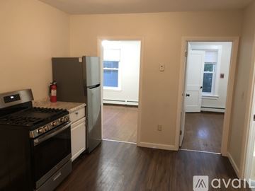 Pawtucket apartment for rent - A kitchen with a black stove top oven and a black refrigerator.