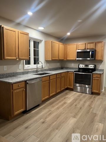 Milford townhouse for rent - A kitchen with wooden cabinets and a granite countertop.
