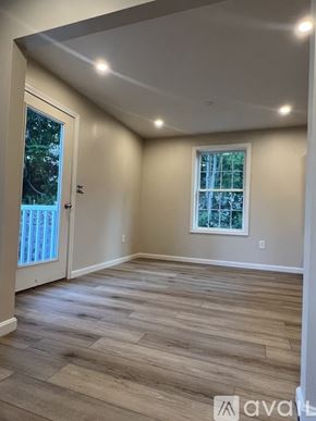 Milford townhouse for rent - A room with wooden flooring and a window with a view of trees.