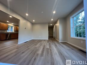 Milford townhouse for rent - A spacious room with wooden flooring and a large window on the right side.