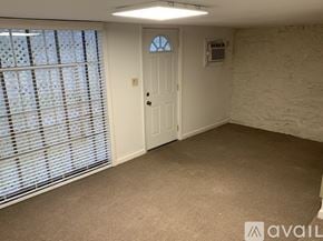 Berry Hill house for rent - A room with a door, window with blinds, and a wall socket.