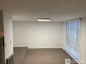 Berry Hill house for rent - A spacious room with a carpeted floor and a window with blinds.