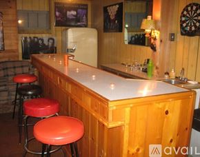 Syracuse house for rent - A bar with a white counter and red stools.