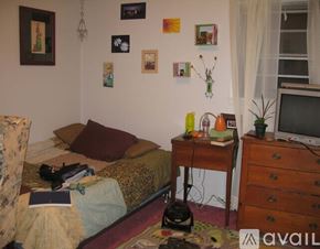 Syracuse house for rent - A bedroom with a bed, desk, and chair.