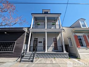 New Orleans apartment for rent - A two-story house with a balcony and a small porch.