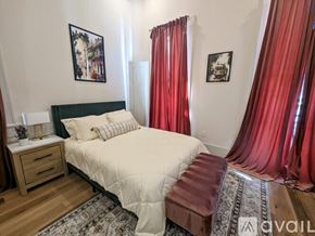 New Orleans apartment for rent - A bedroom with a large bed and red curtains.