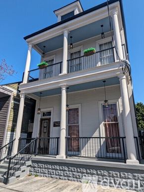 New Orleans apartment for rent - A white two-story building with a balcony on the second floor.
