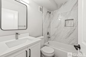 North Palm Beach apartment for rent - A bathroom with a marble wall and a white toilet.